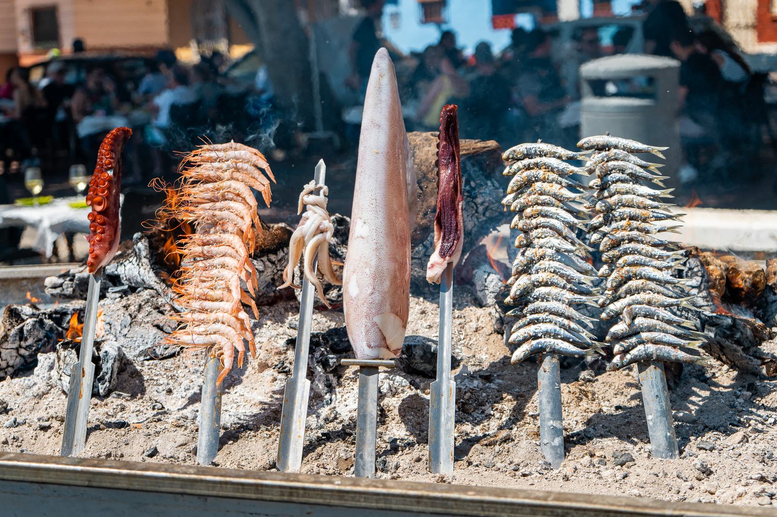 Espetos y pescado sobre la brasa